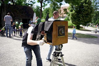 Eine Person bedient eine historische Kamera